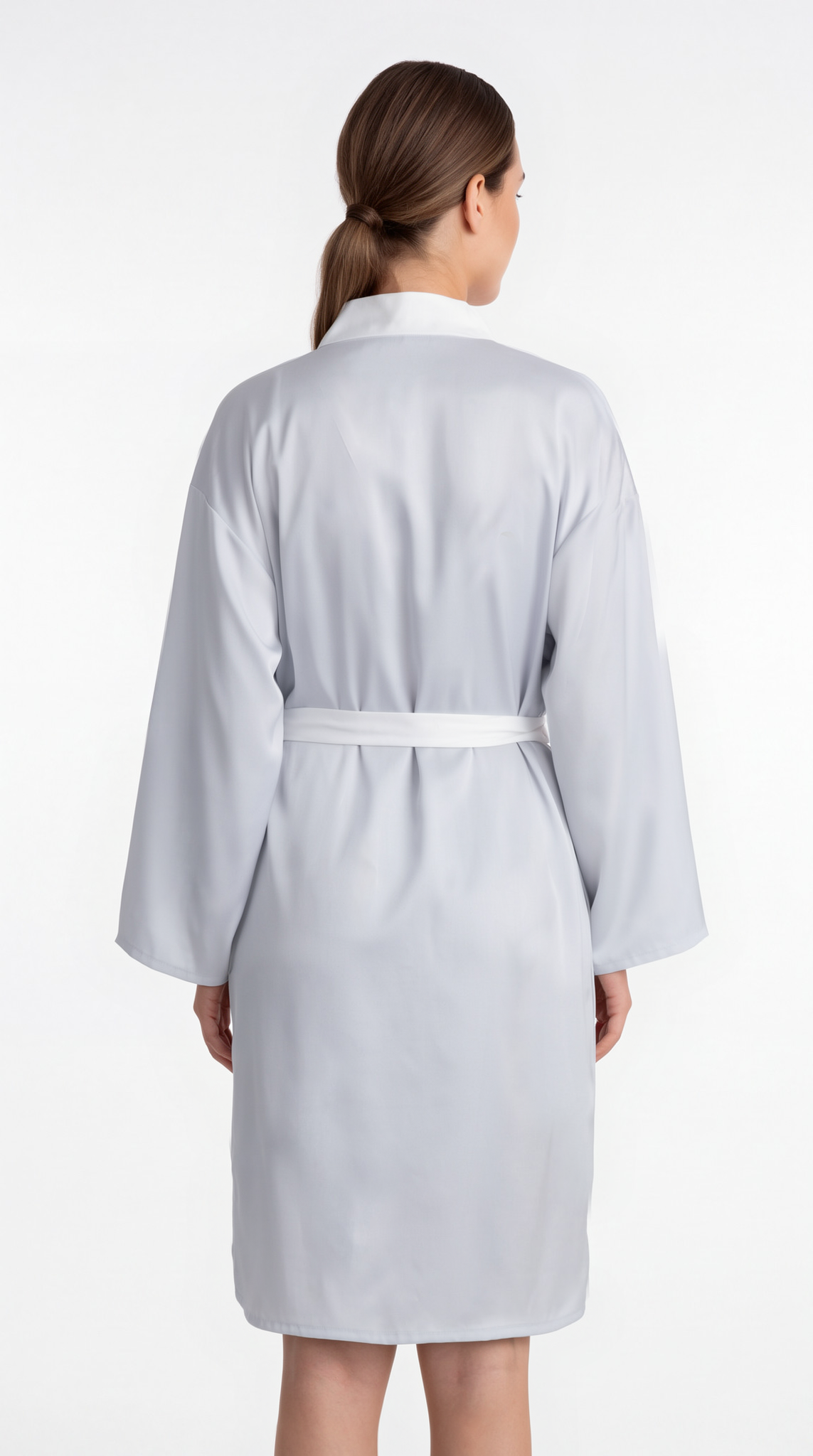 A woman viewed from the back wearing a light gray bathrobe with a white collar and a matching waist tie, set against a plain white studio background.