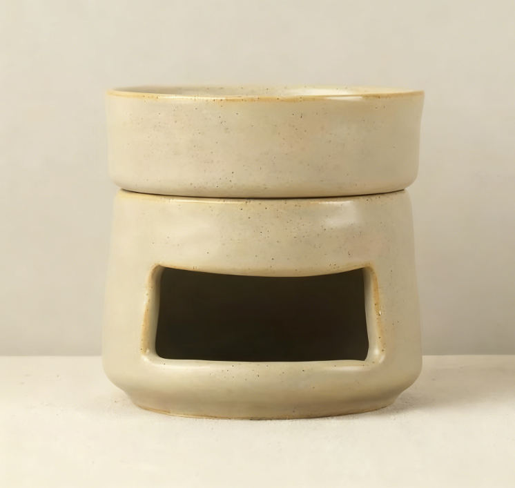 VibraMist Mother Earth ceramic fragrance warmer in speckled beige, with a shallow top dish and rectangular tea light opening.