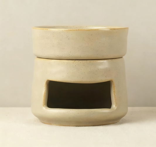 VibraMist Mother Earth ceramic fragrance warmer in speckled beige, with a shallow top dish and rectangular tea light opening.