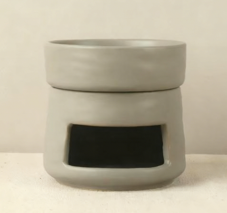 VibraMist Mother Earth ceramic fragrance warmer in soft gray, with a matching top dish and rectangular tea light opening.