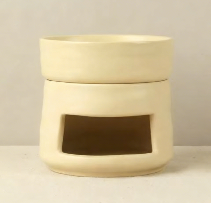 VibraMist Mother Earth ceramic fragrance warmer in warm white, showing its rounded base, shallow dish, and rectangular tea light opening.