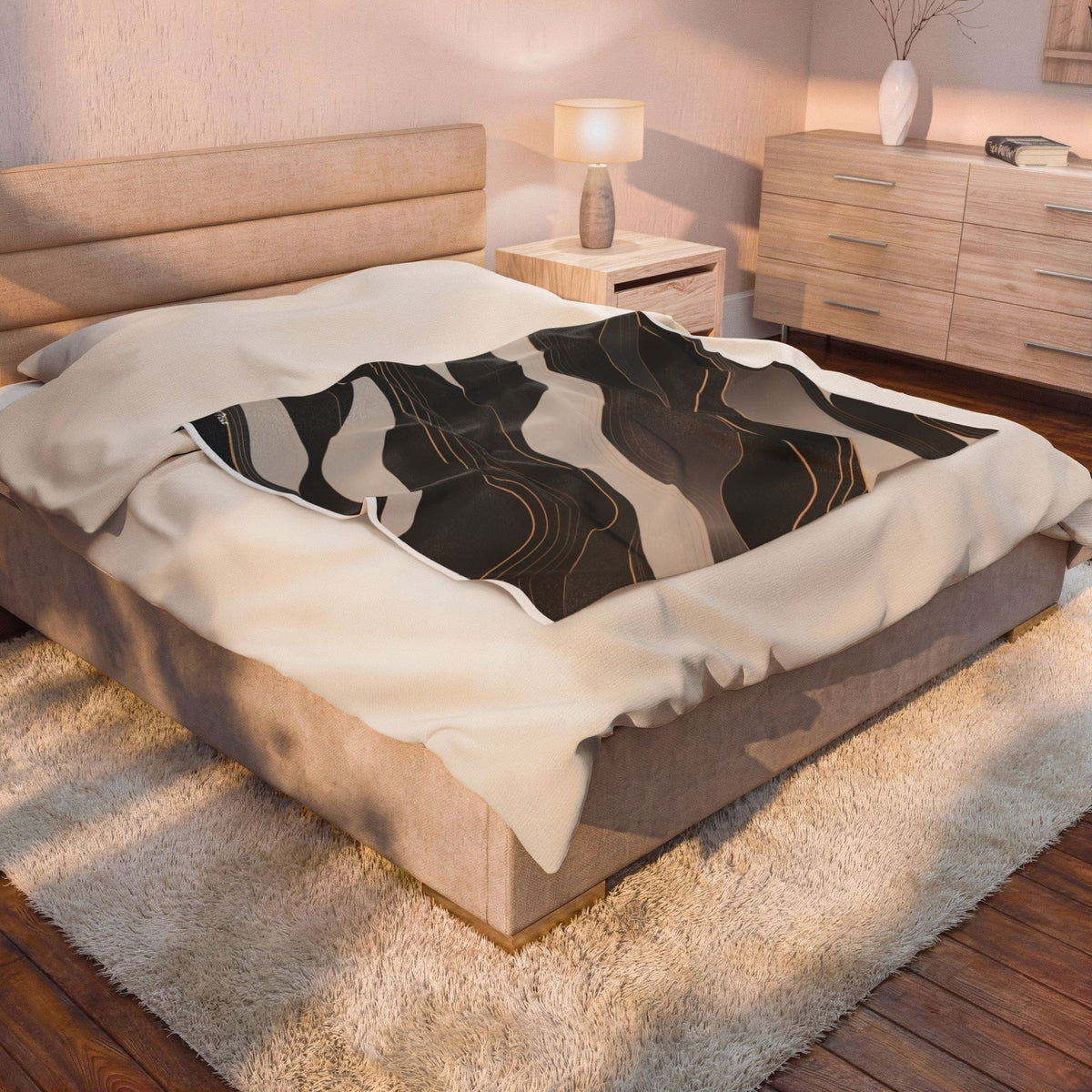 A modern upholstered bed in a warm-toned bedroom, styled with cream bedding and a black, gray, and beige abstract patterned throw blanket.