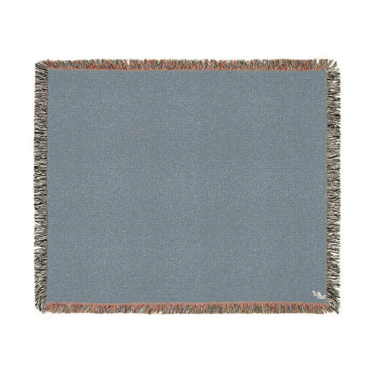 A square woven throw blanket in a slate blue-gray color, featuring fringed edges with a mix of gray, rust, and white threads, shown flat against a white background.